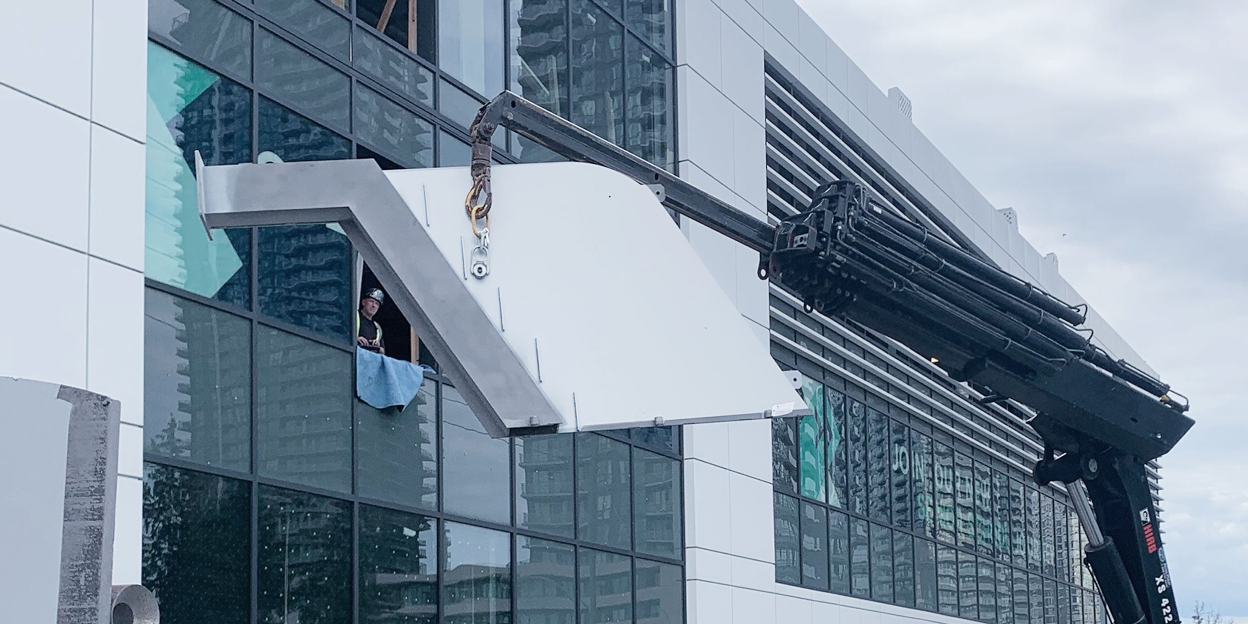 photo of crane moving a staircase through a window