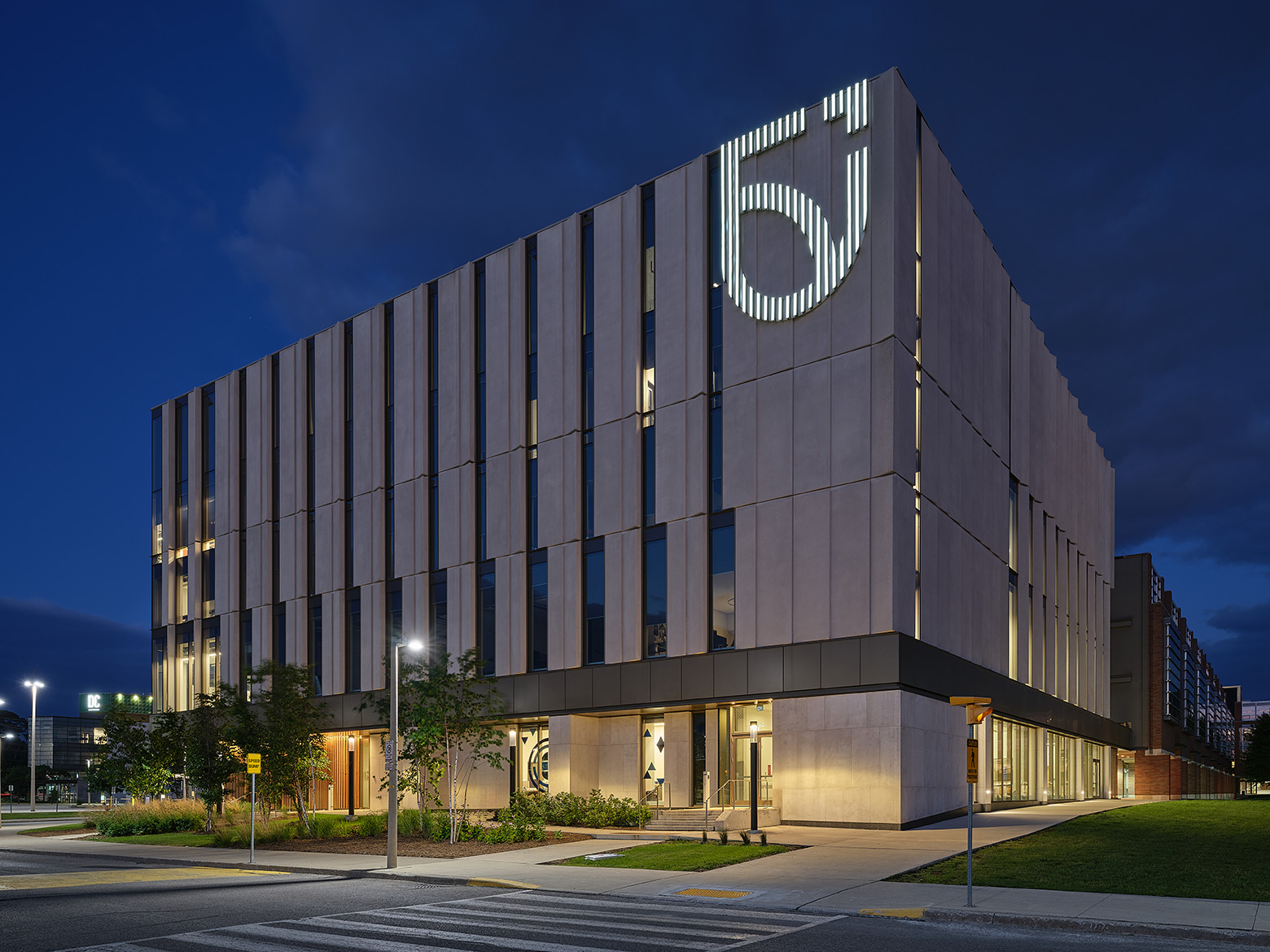 Exterior photo at night of Shawenjigewining Hall, Ontario Tech University